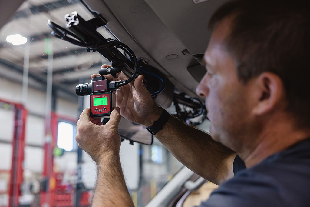 A man installing a camera inside a vehicle