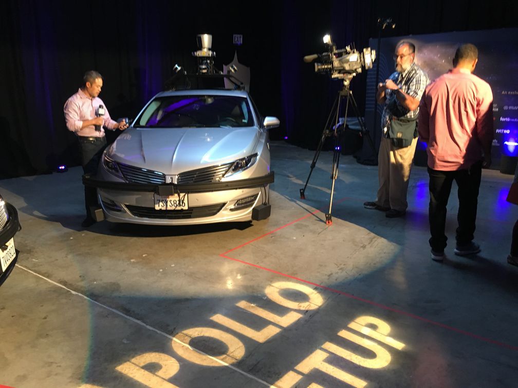 Man being filmed while standing next to vehicle