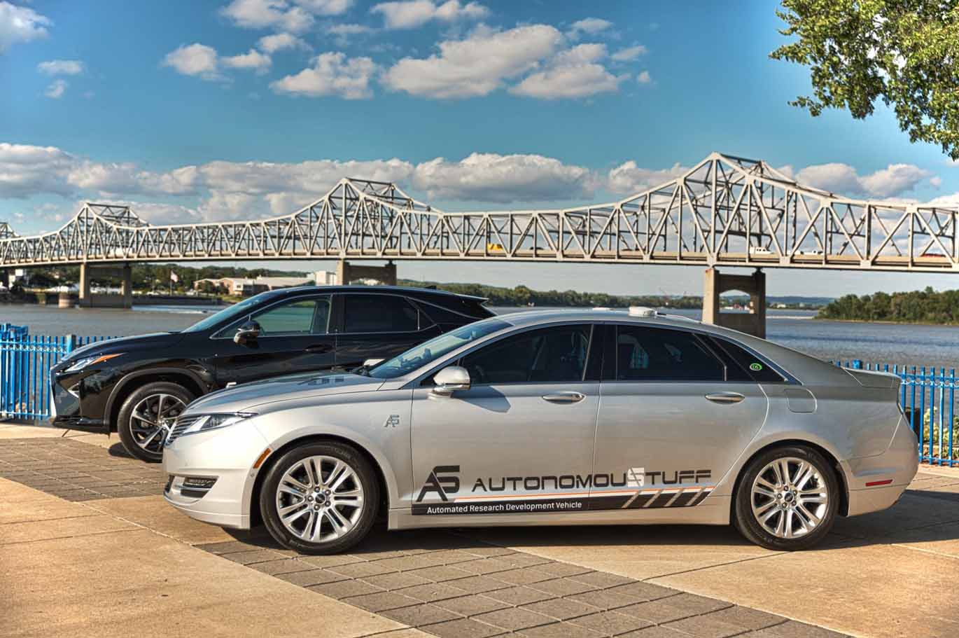 Two AS branded vehicles with bridge in background