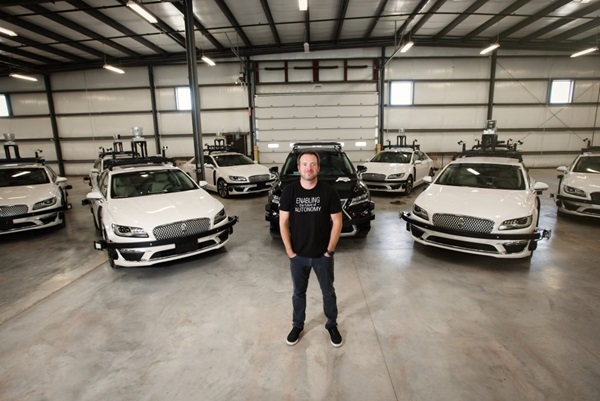Photograph of Bobby standing in front of vehicles