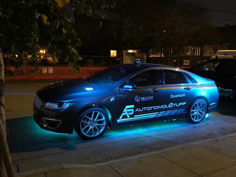 AutonomouStuff branded vehicle with glowing lights at night