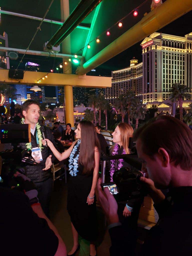 A man being interviewed on a crowded patio