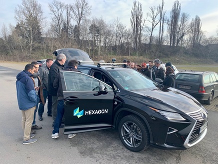 Hexagon branded Lexus outside with doors open and people looking inside