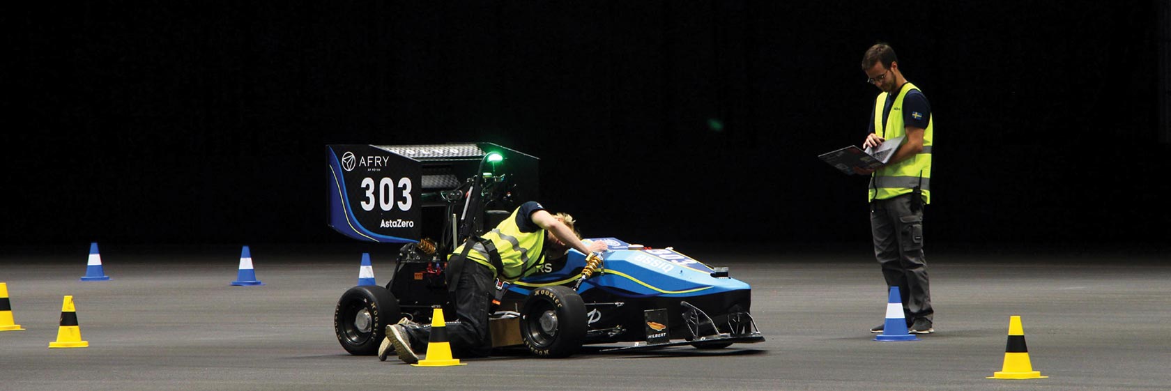 Race car on a track with a man standing next to it